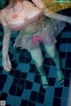 A woman in a pink dress standing in a pool.