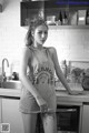 A woman standing in a kitchen next to a sink.