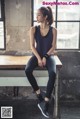 A woman sitting on a bench in front of a window.