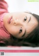 A young woman laying on the ground looking up at the camera.