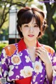 A woman in a purple and orange kimono posing for a picture.