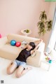 A woman laying on the floor in front of a couch.