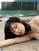 A woman laying on a beach next to the ocean.