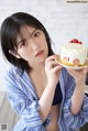 A woman holding a plate with a cake on it.