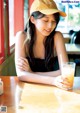 A woman sitting at a table with a glass of orange juice.