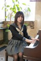 A woman sitting at a piano in a room.