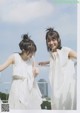 Two young women standing next to each other on a balcony.