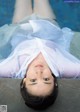 A woman laying on the edge of a swimming pool.