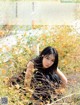 A woman sitting in a field of yellow flowers.