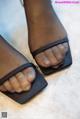 A close up of a woman's feet wearing black sandals.