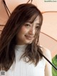 A woman with long brown hair holding an umbrella.