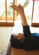 A woman laying on the floor with her hands up in the air.