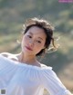 A woman in a white blouse posing for a picture.